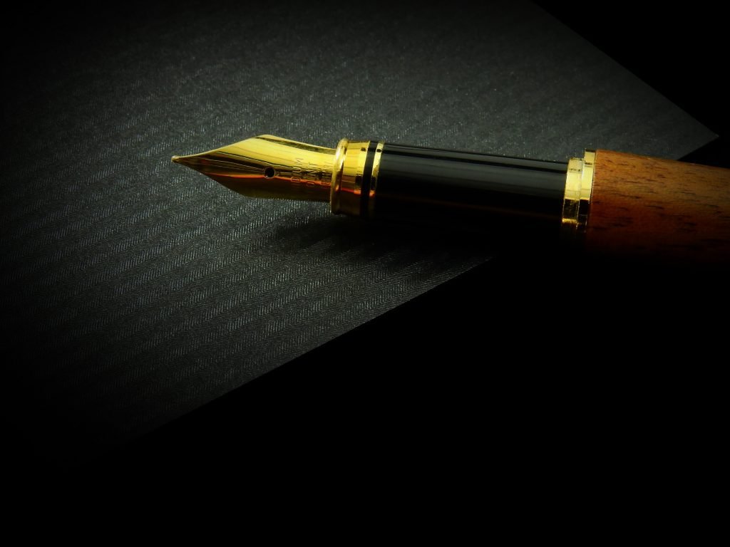 black-gold-fountain-pen-on-top-of-a-black-book